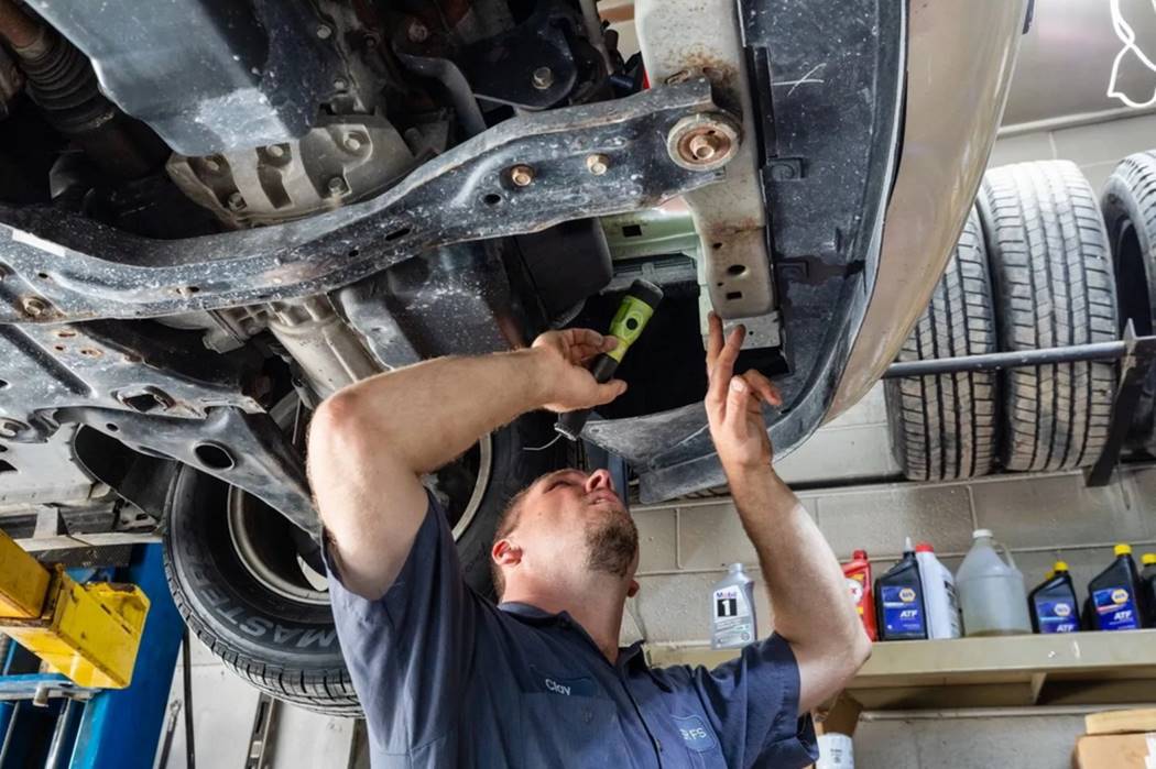 Technician working under a vehicle at Corner FS